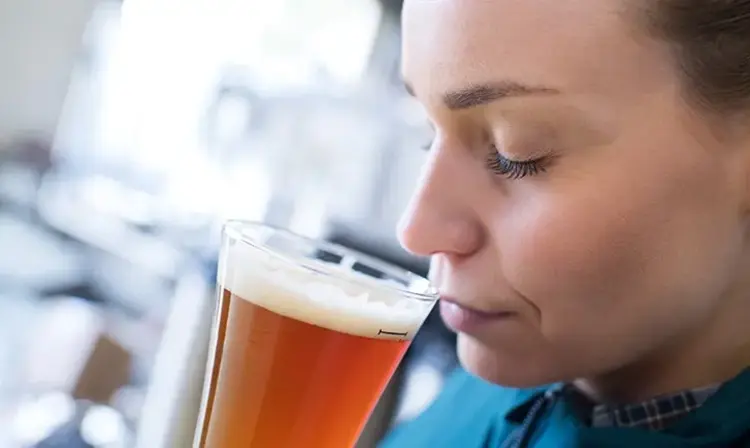a woman drinking a glass of beer